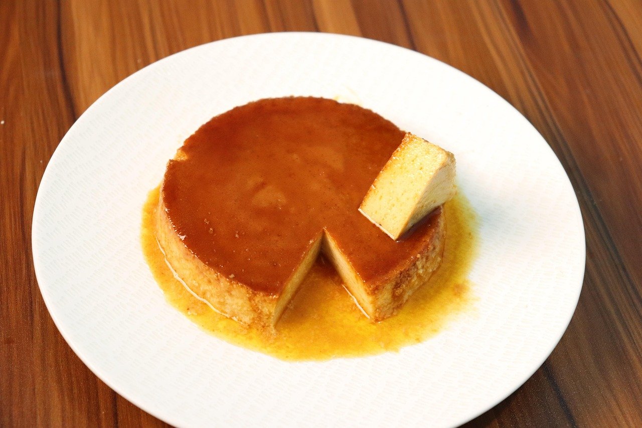 Flan casero con caramelo y una porción cortada en un plato blanco