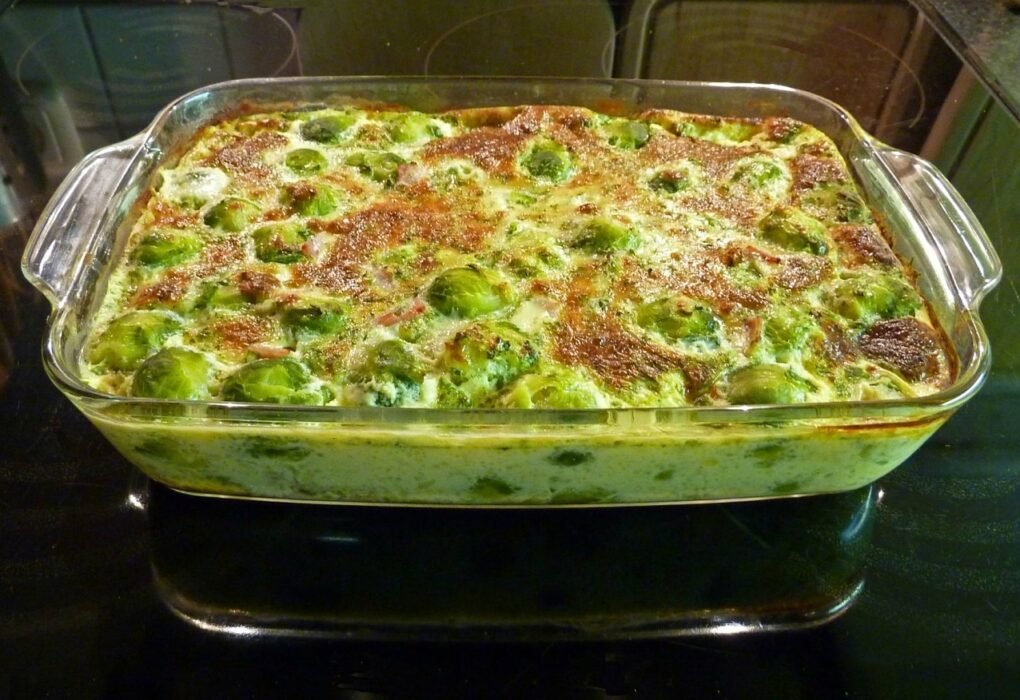 Fuente de cristal rectangular con coles de Bruselas gratinadas y doradas en el horno.