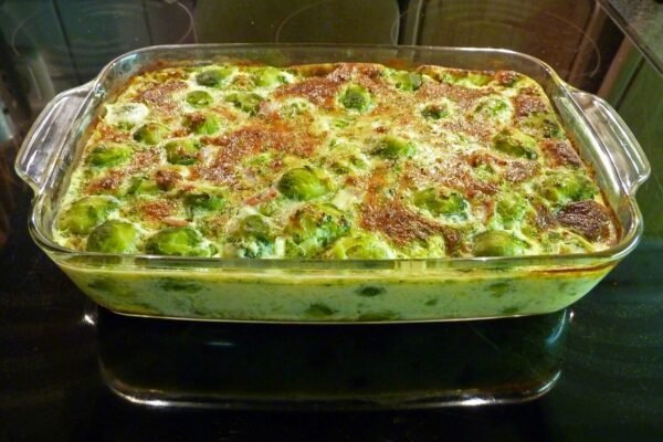 Fuente de cristal rectangular con coles de Bruselas gratinadas y doradas en el horno.