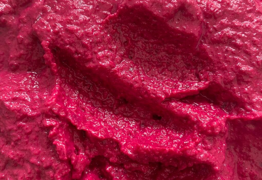 Hummus de remolacha de color rosa intenso en un bol.